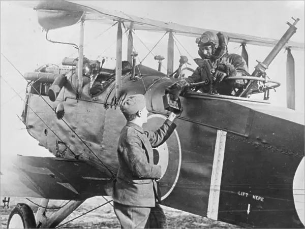 The observer of an Airco DH. 4 is handed a magazine of photographic plates