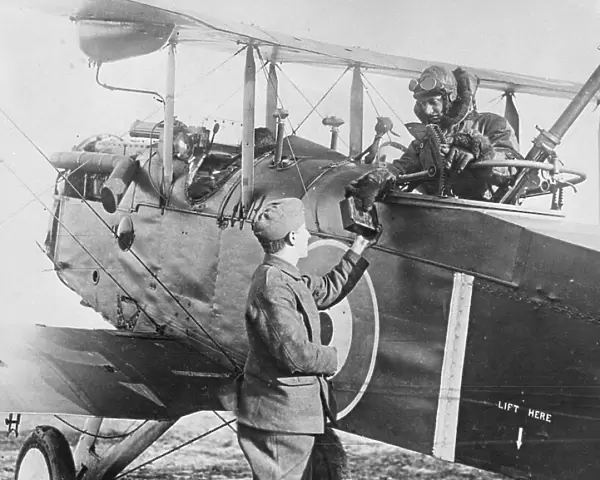 The observer of an Airco DH. 4 is handed a magazine of photographic plates