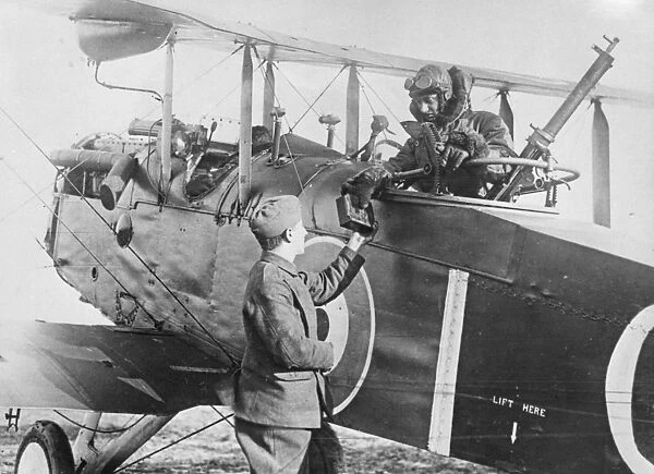 The observer of an Airco DH.4 is handed a magazine of photograph