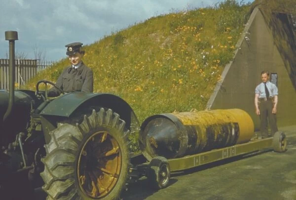 WAAF tractor driver. A WAAF tractor driver leaving the bomb dump with a